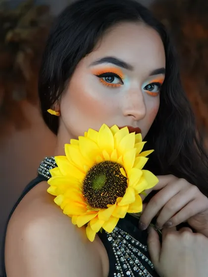 Using a sunflower as a prop, this shot emphasizes the color story and the playful, artistic nature of the makeup.