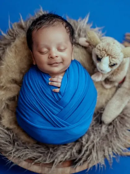 A smiling sleeper. This overhead shot of a swaddled baby shows off their happy dreams and the beautiful texture of the wrap.