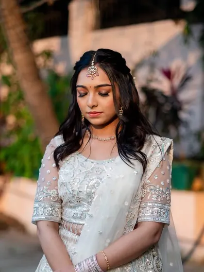 A serene and pensive pose. The soft eye makeup and glowing skin create a look that is both romantic and sophisticated.