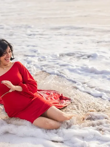 Pure joy as the waves kiss her feet. We love capturing these candid moments of happiness and laughter during our fun and relaxed beach sessions.