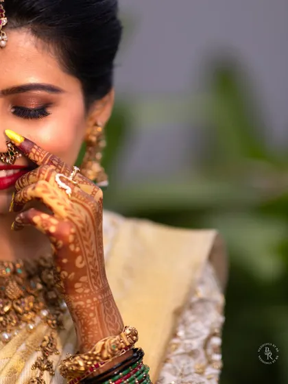 A beautiful close-up of the bride's happy expression, focusing on her smile, henna, and nose ring.