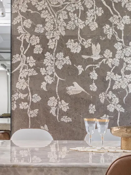A detailed view of the exquisite stone mosaic inlay, featuring delicate birds and foliage. This custom art piece serves as a sophisticated focal point in the dining room, showcasing our commitment to bespoke craftsmanship.