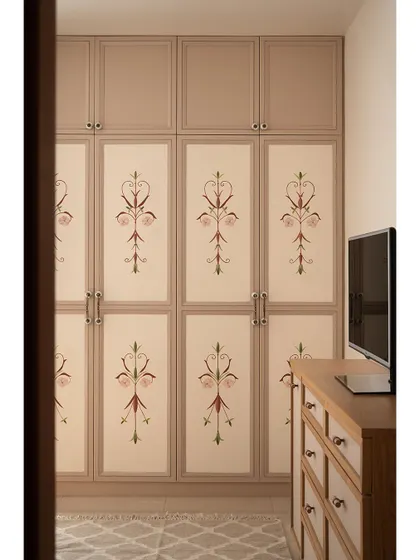 The parents' bedroom wardrobe features beautiful custom hand-painted shutters. The delicate floral motif harmonizes with a mural on the adjacent wall, creating a warm and personal space.