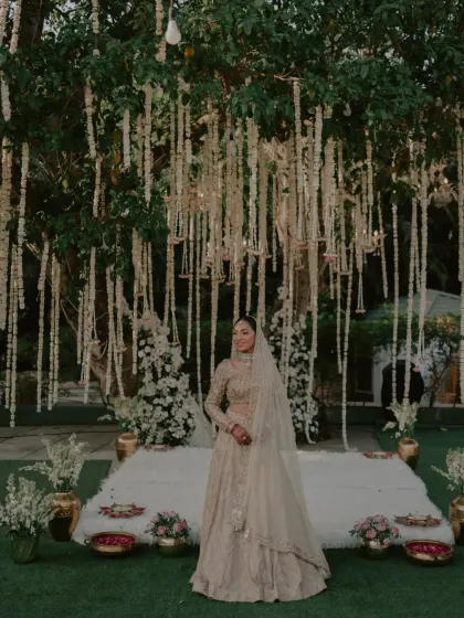 A stunning bridal portrait with the bride standing before her beautiful wedding mandap.