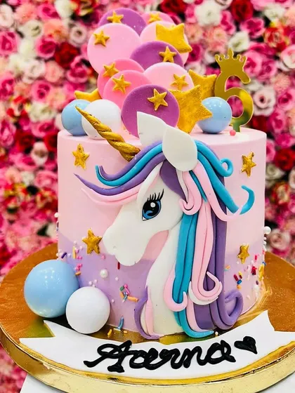 This unicorn cake is bursting with color and magic. The detailed fondant unicorn, stars, and spheres make it a vibrant centerpiece for a 6th birthday party.