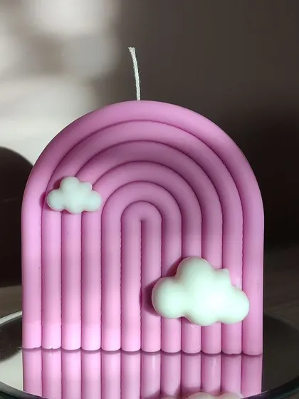 A close-up of the pink rainbow candle, showing its clean lines and cute cloud details.