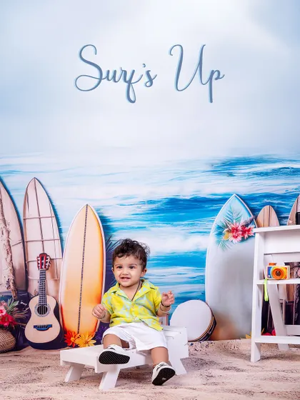 Surf's up! This happy baby is enjoying the beach vibes, sitting on a little bench with his guitar, ready to catch some waves or play a tune.