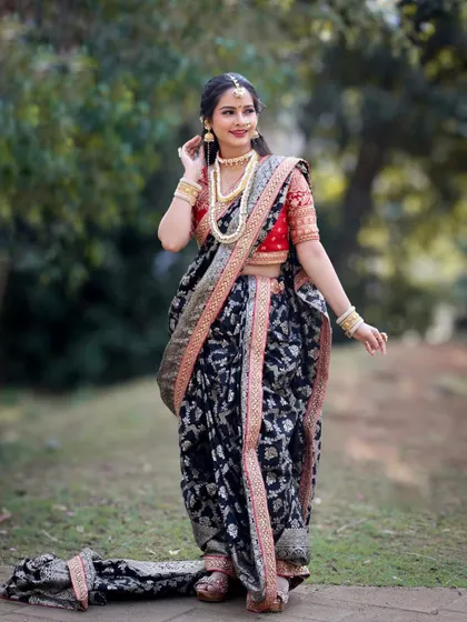 A full-length view of the black brocade Nauvari, showing its elegant drape and rich texture.