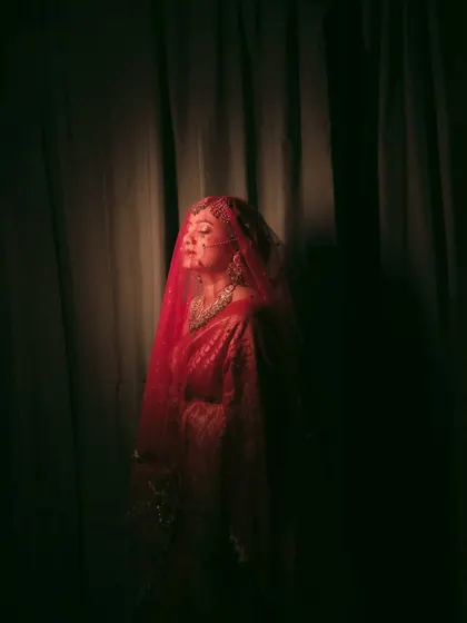An artistic bridal portrait, using a red light filter and shadows to create a bold and dramatic image.