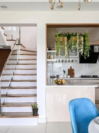 This open-plan design beautifully integrates the kitchen with the dining and living areas. The hanging planter box over the breakfast counter defines the kitchen space and adds a fresh, natural element.