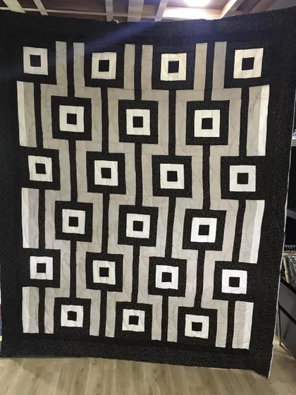 A high-contrast, black and white geometric quilt with a retro-modern feel.