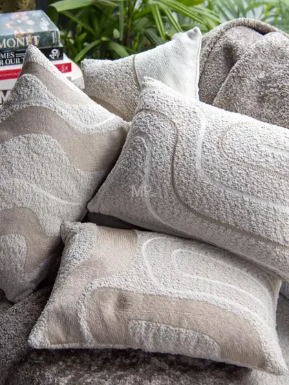 Another view of our textured bouclé cushions, highlighting the abstract embroidered lines that add understated luxury and comfort to your lounging experience.