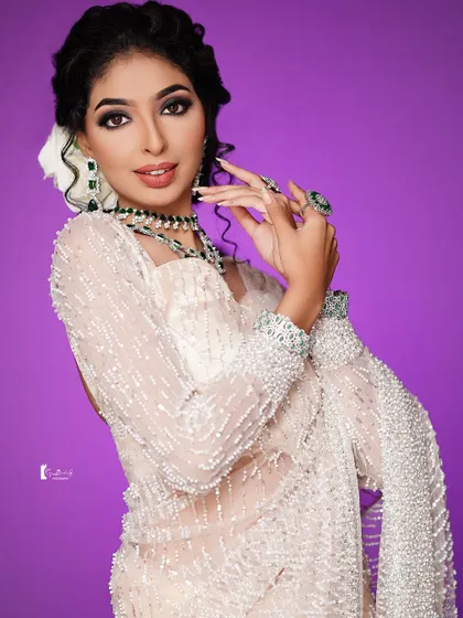 A playful and chic pose that highlights the beautiful jewelry and makeup.