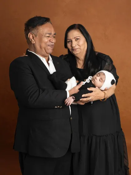 The special bond between grandparents and their grandchild. The pride and love in their expressions as they hold the sleeping newborn is a truly priceless moment.