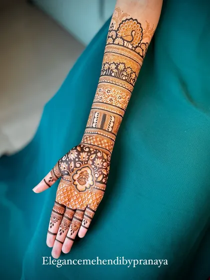 A single arm view of an elegant bridal mehendi, showing the beautiful flow of patterns from the hand to the elbow.