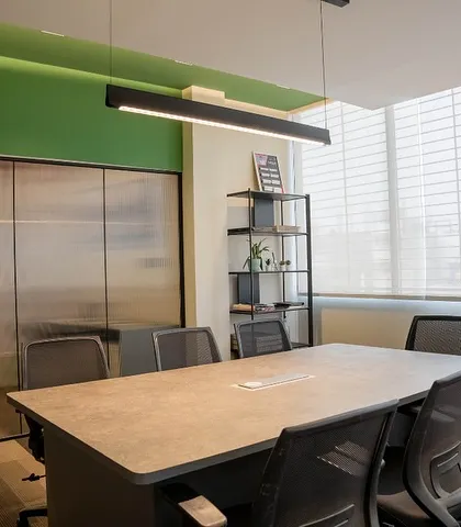 A different angle of the conference room, showing the frosted glass partitions that offer privacy without completely closing off the space.