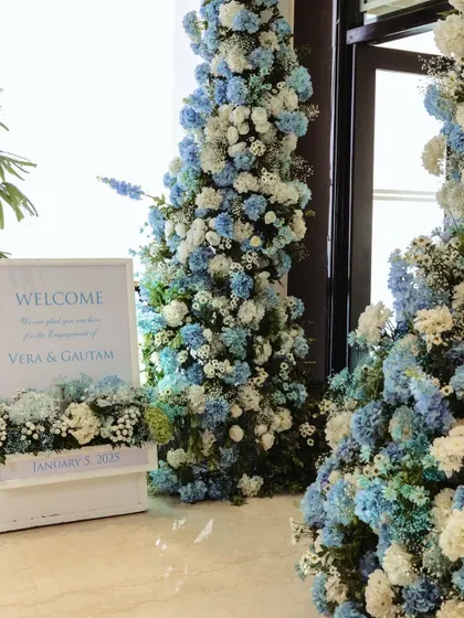 A stunning floral arch of blue and white hydrangeas welcomes guests to the engagement party, setting a fresh and elegant tone from the moment they arrive.