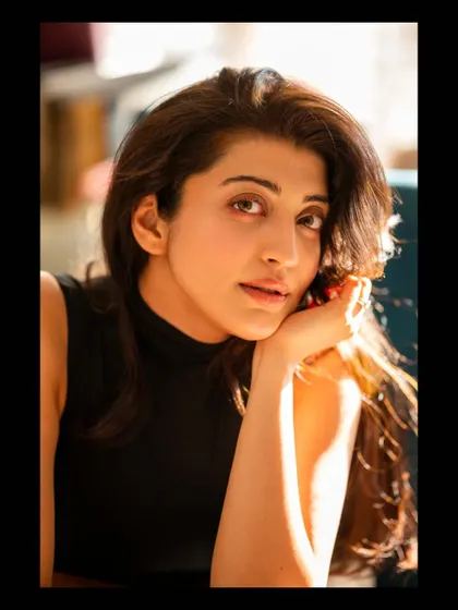 A thoughtful portrait of Pranitha, using the natural light to create a serene and contemplative mood. The focus is on capturing a quiet, authentic moment.