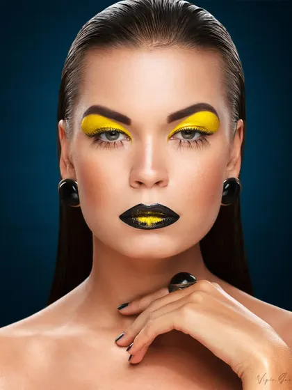 A powerful beauty portrait featuring a bold yellow and black makeup theme. The model's direct gaze and the flawless application make for a captivating commercial beauty image.