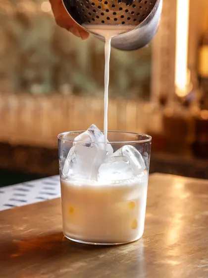 The Lemongrass Pina Colada, a tropical classic with a zesty, aromatic twist from our house-infused rum.