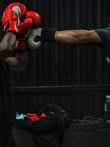 A fighter lands a straight right hand. The dark background focuses all attention on the action.