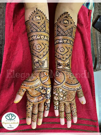 A custom bridal mehendi featuring elephants, a 'doli' (palanquin), and the couple's names, creating a rich and narrative design.
