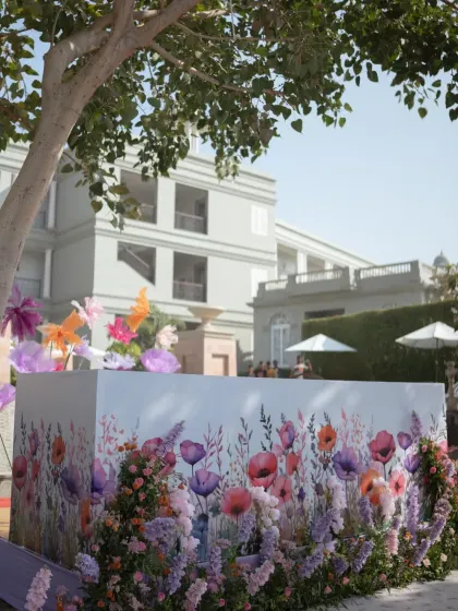 A bar or food station with a custom-printed front featuring a beautiful watercolor floral design, tying into the lavender carnival theme.