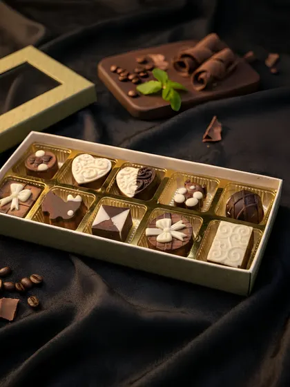Decorated chocolates fill a divided gift box in our catalogue, showing mixed shapes and patterned finishes for gifting.
