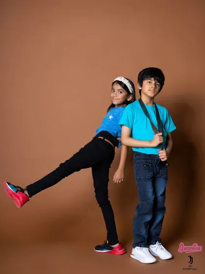 A fun, interactive pose between two child models. This creates a dynamic image and shows how the clothes look in a more active, playful context.