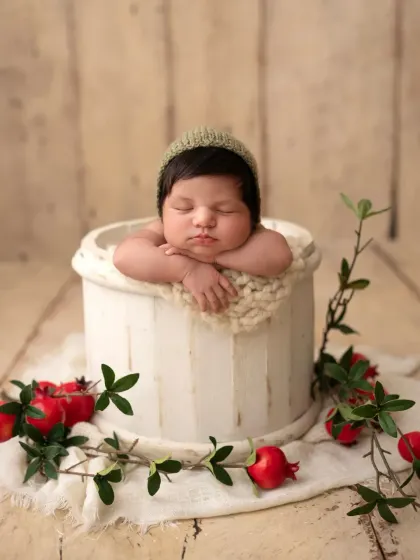 Adding a simple knitted bonnet changes the feel of the portrait. Here, the baby boy looks extra cozy in the same rustic bucket setup.