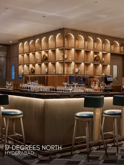 The bar at 17 Degrees North is a statement of modern luxury. Arched wooden shelving, a dark marble countertop, and elegant bar stools create a sophisticated space for members to socialize.