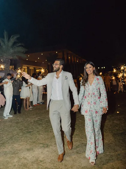 Mouli and Jaymit make a grand entrance, holding hands and surrounded by sparklers. This shot is full of energy, celebration, and romance.
