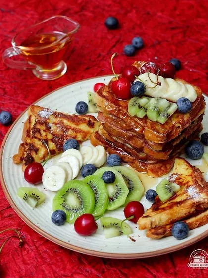 Another angle of the beautifully arranged French toast breakfast, complete with a side of syrup. This series shows how different perspectives can be used in a single food photoshoot.