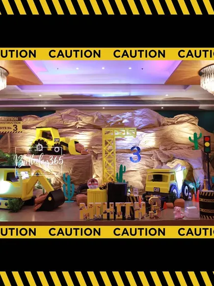 A wide shot of the entire construction party stage, showing the impressive scale of the custom-built props.