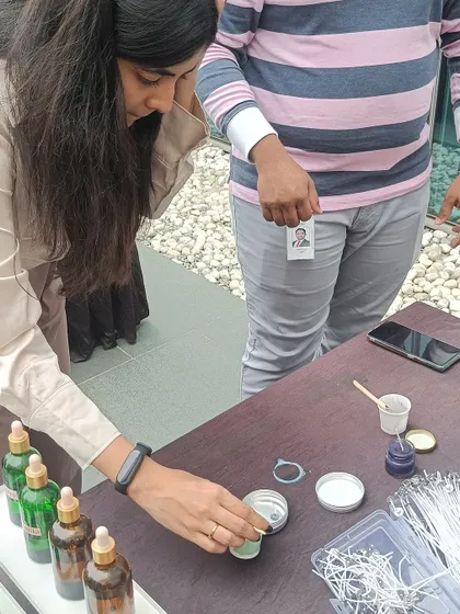 A participant at our Eco Space booth carefully adds fragrance oil to her candle, personalizing its scent.