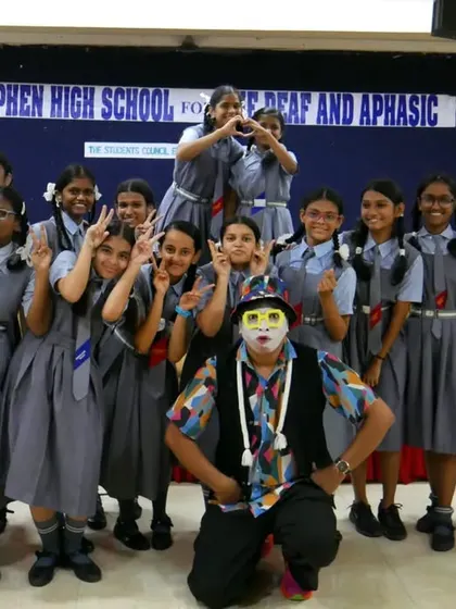 A group photo of the girls from Stephen's High School with the 'Silent Storyteller'. Their smiles and playful poses show how much they enjoyed the unique and inclusive performance.