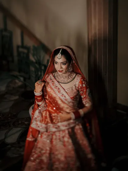 A classic bridal portrait, with the bride looking elegant and thoughtful in a softly lit, intimate setting.