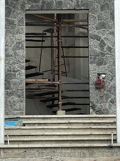 A duplicate image of the hill house construction, focusing on the texture of the random rubble stone wall.
