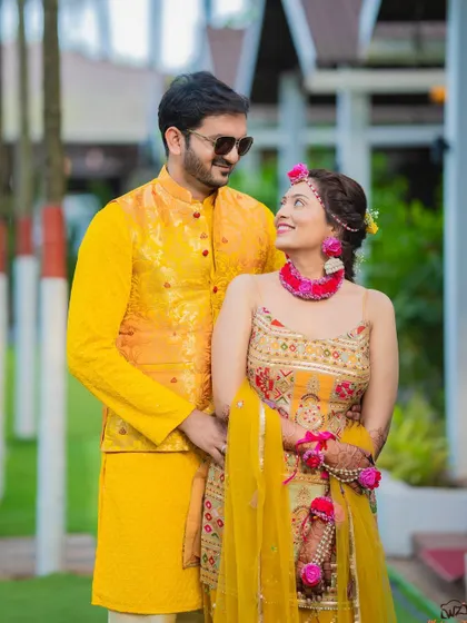 A sweet moment between the couple at their Haldi ceremony, sharing a look amidst the yellow-themed celebrations.