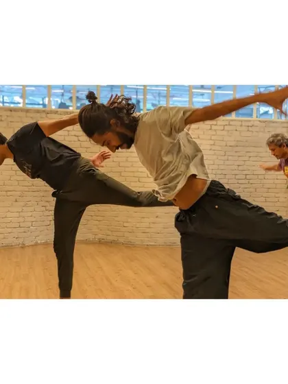 Two dancers practice a balance exercise, demonstrating the focus and control developed in our contemporary classes.
