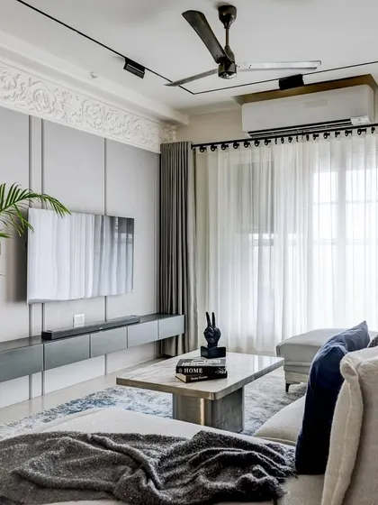 The living room of the 'YBJ Residence' is a study in European elegance and comfort. We used a soothing grey palette, a plush custom sofa, and clean lines to create a sophisticated yet inviting atmosphere. The ornamental moulding on the TV wall adds a classic touch to the modern space.