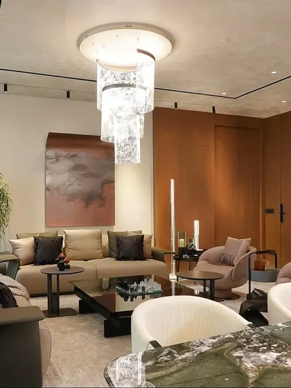 A view of the living and dining area at The Amaryllis, showcasing a harmonious blend of earthy tones and tactile materials. The design features a sculptural chandelier, comfortable seating, and curated art to create a warm and inviting atmosphere.