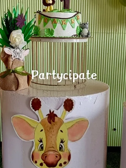 Details from Ekaksh's safari party, showing the cake on a stand and a cute giraffe-themed pedestal. Every element is chosen to reinforce the jungle adventure theme.