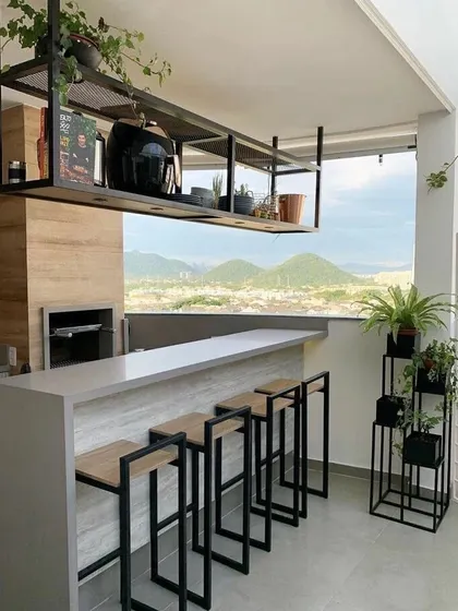 Even a modern, minimalist space can be enhanced with plants. For this balcony bar, we added a few carefully chosen plants in simple pots and a multi-tiered stand to soften the look without cluttering the stunning view.
