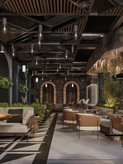 This long shot of the restaurant shows the different seating zones, from comfortable sofas to dining tables. The design uses planters and varied flooring to define spaces within the open-plan layout.