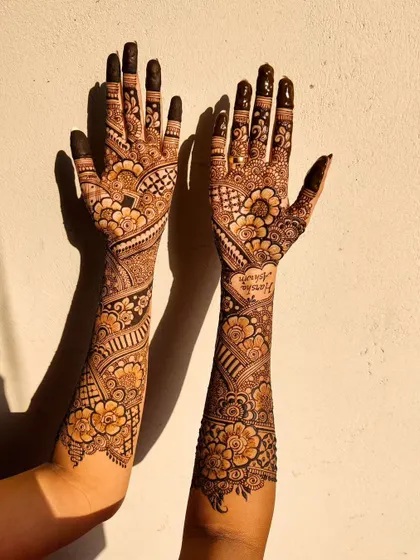 The sunlight brings out the warm, rich tones of this mature bridal henna stain. The color is consistent from the fingertips all the way up the arms.