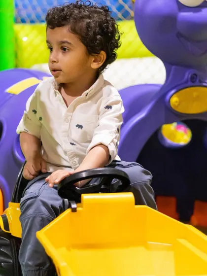 A little farmer getting to work on his bright yellow tractor. It's all about imaginative fun in our vehicle corner.