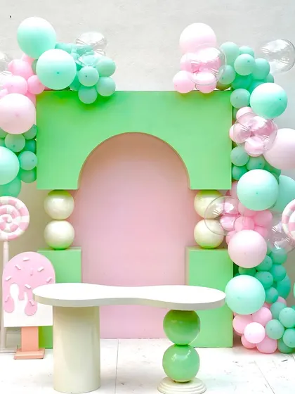 A sweet setup for a candyland or nutcracker-themed party, featuring our pastel green sphere box arch, sphere base table, and life-size nutcracker props.