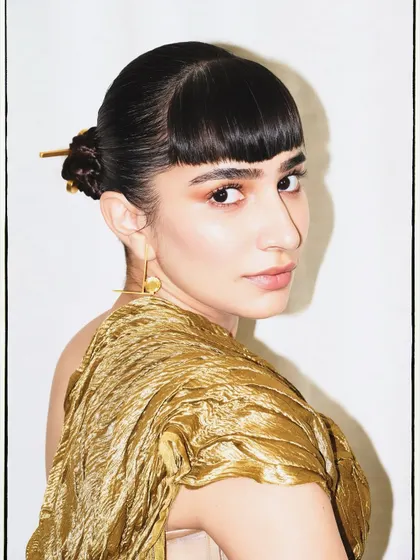 A beauty shot capturing the essence of the look, with a focus on the unique texture of the gold top and the sharp, modern hairstyle.