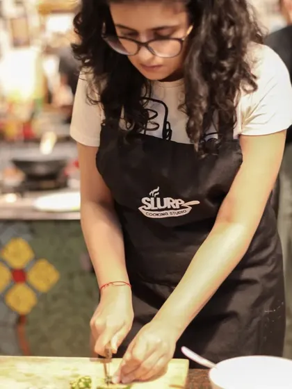 Learning is in the details. A student carefully chops ingredients, absorbing the techniques taught by our expert chefs.